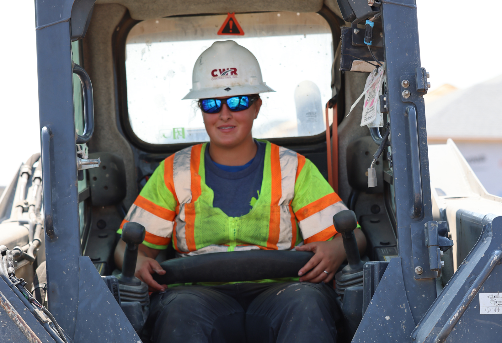 cwr contracting employee smiling sitting in a front loader